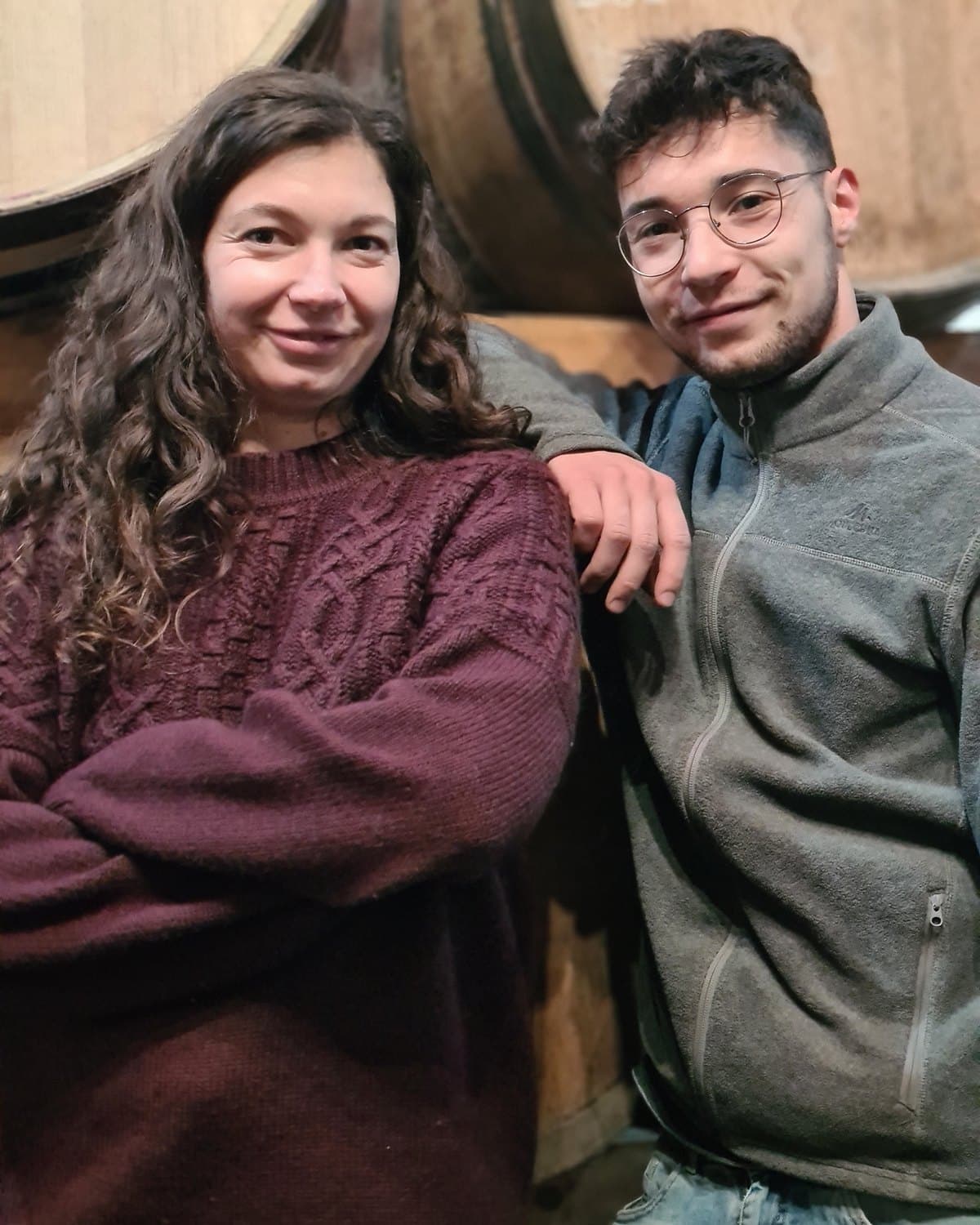 Sarah et Charly Bideau, frère et sœur, devant les barriques du chai